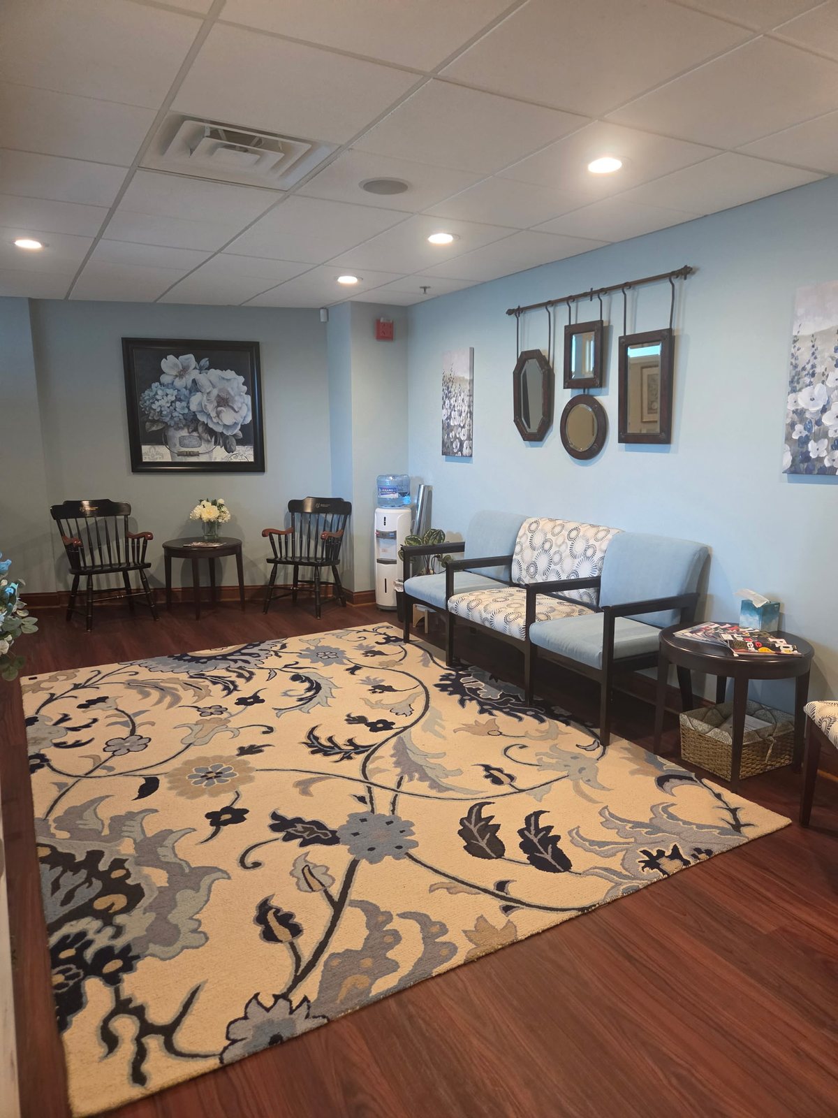 The waiting room in Suite 202 with its seating area and floral rug
